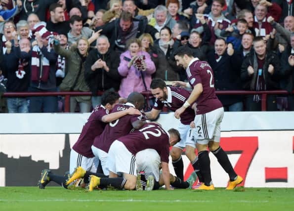 Jason Holt (hidden) is mobbed by his team-mates after putting Hearts 1-0 up. Picture: SNS