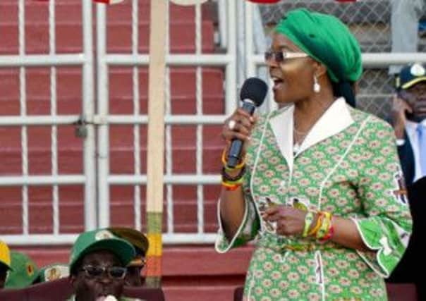 Robert Mugabe eats an ice cream while his wife Grace addresses a rally. Picture: AFP/Getty