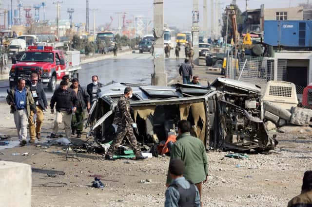 Investigators inspect the wreckage of the embassy jeep in Kabul after a Taleban suicide car bomber reportedly rammed it. Picture: AP