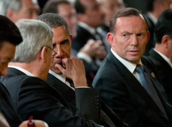 Tony Abbott, right, looks on as Barack Obama, centre, talks to Canadian prime minister Stephen Harper. Picture: AP