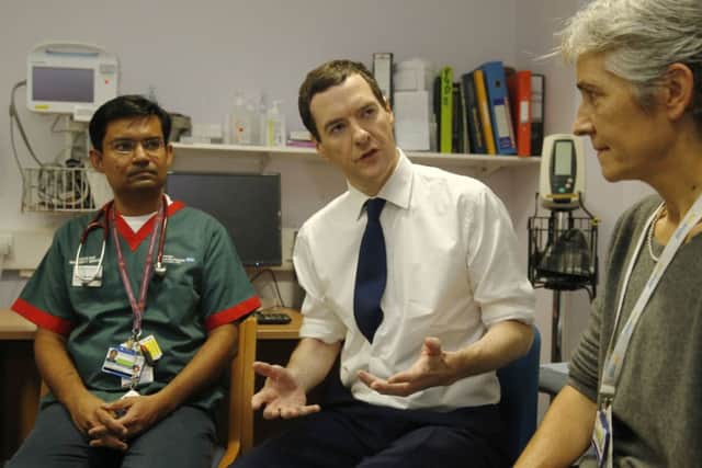 George Osborne, who will set out plans for more NHS cash, talks to doctors at an London hospital yesterday. Picture: Reuters