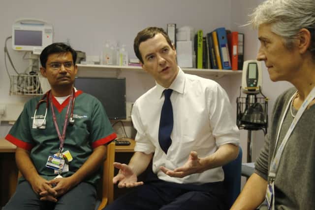 George Osborne, who will set out plans for more NHS cash, talks to doctors at an London hospital yesterday. Picture: Reuters