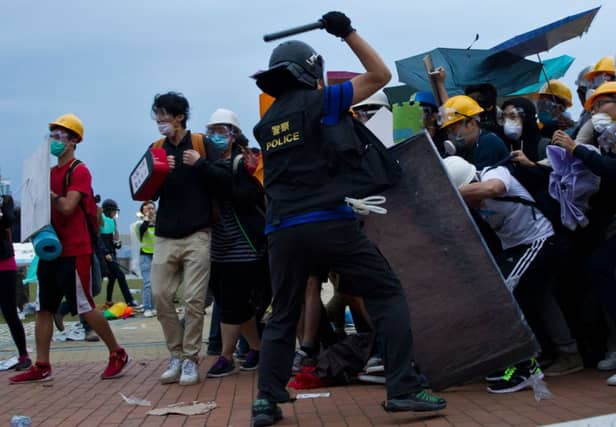 A policeman wielding a baton clashes with protesters as the authorities attempt to clear a road occupied by campaigners. Pictures: Getty