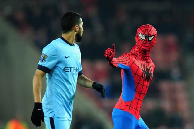 Gael Clichy appears rather nonplussed by Spider-Man's pitch invasion. Picture: Getty