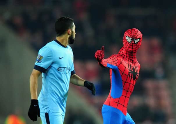 Gael Clichy appears rather nonplussed by Spider-Man's pitch invasion. Picture: Getty