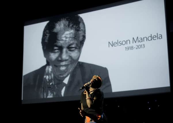 A singer performs onstage in front of a portrait of former South African president Nelson Mandela. Picture: Getty
