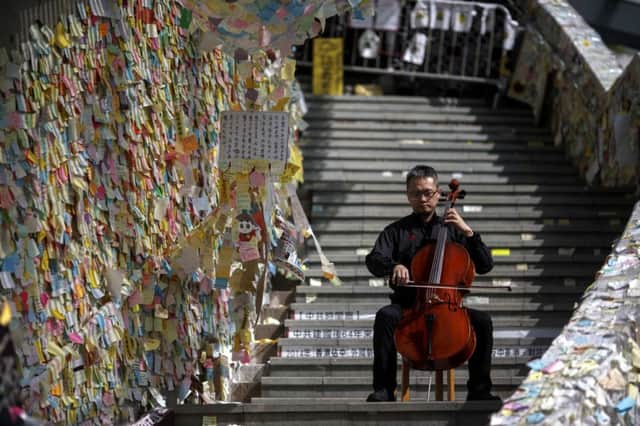 Cellist David Wong performs by a wall of messages of support for protesters at Admiralty. Picture: Reuters