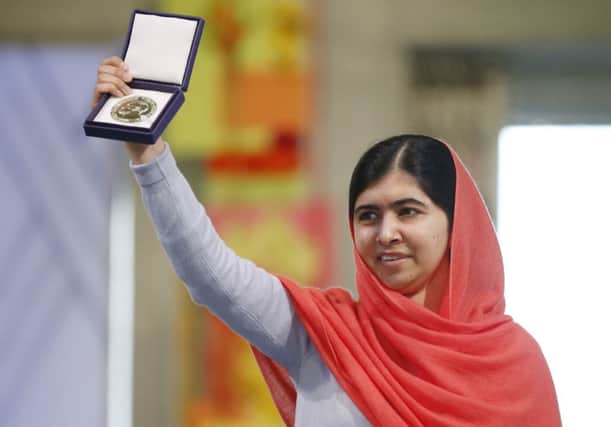 Malala Yousafzai holds up her gold medal at the Nobel Peace Prize ceremony in Oslo yesterday. Picture: AP