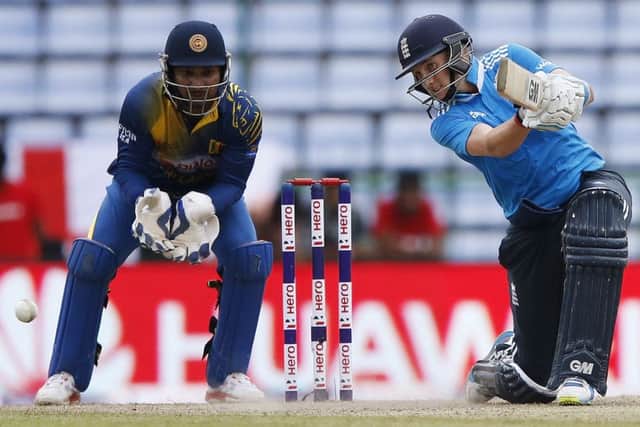 Englands Joe Root hits out on his way to an unbeaten 104 as Sri Lanka wicketkeeper Kumar Sangakkara looks on. Picture: Reuters