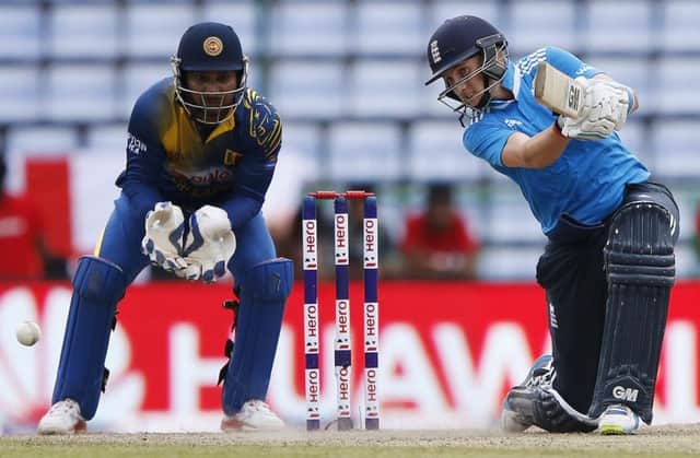 Englands Joe Root hits out on his way to an unbeaten 104 as Sri Lanka wicketkeeper Kumar Sangakkara looks on. Picture: Reuters