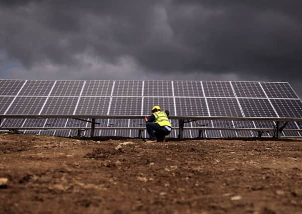 An engineer works on the installation of a photovoltaic panel array. Picture: Getty
