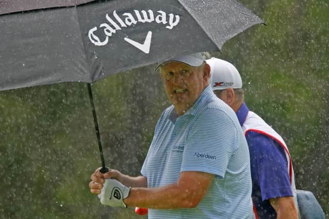 Colin Montgomerie shelters under his umbrella during a shower in the opening round in Mauritius. Picture: Getty