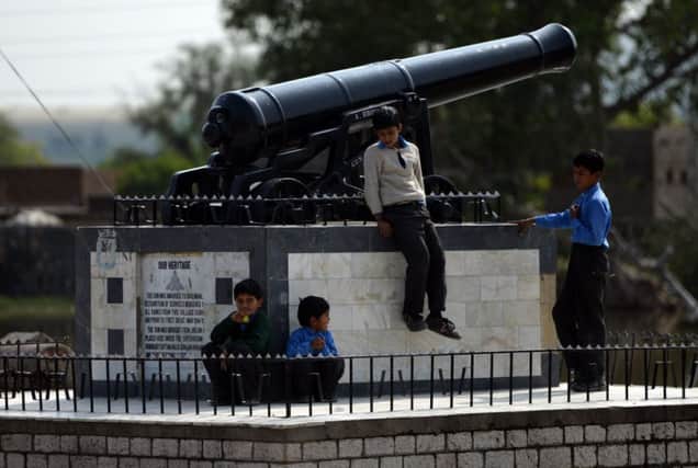 Children playing beside the cannon in the village of Dulmial. Picture: Getty