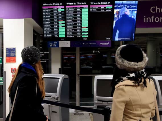 Passengers scan for flight information amid cancellations due to computer glitch. Picture: Gordon Fraser