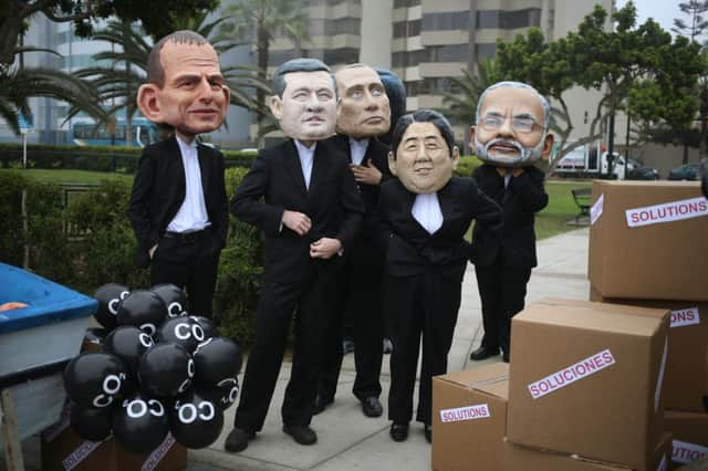 Environmental activists wearing politician puppet faces protest as climate changes talks take place in Peru. Picture: AP