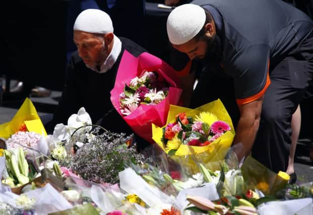Members of the countrys Muslim community place floral tributes. Picture: Reuters