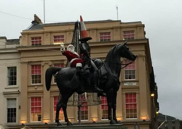 The man dressed as Santa, on top of the Duke of Wellington statue. Picture: Hemedia