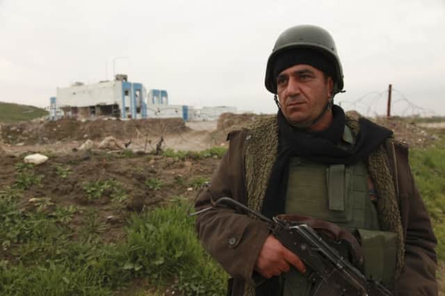 A peshmerga fighter stands guards near a building seized from IS militants. Picture: Reuters