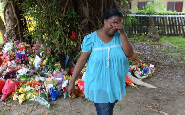 A woman cries after leaving flowers at the house. Picture: Getty