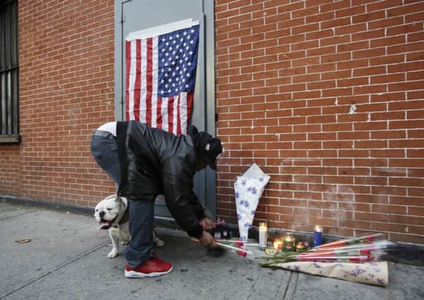 A mourner places flowers at a makeshift memorial for the two NYPD police officers. Picture: AP