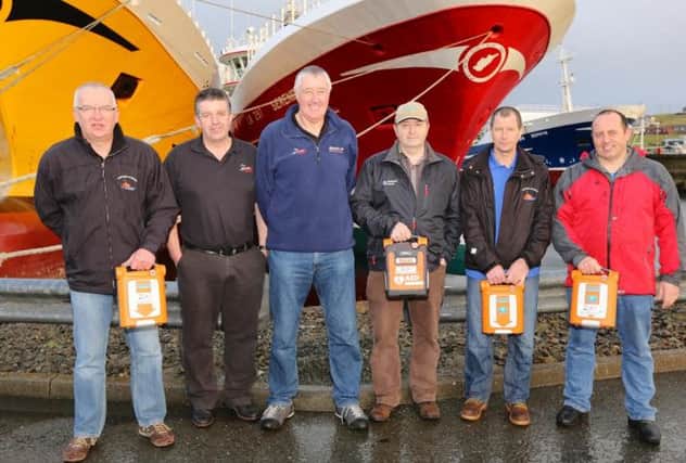 Members of the fishing fleet with the defibrillators due to be fitted on each vessel. Picture: Contributed