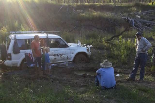 In this Dec 22, 2014 photo provided by Queensland Police, Steven Van Lonkhuyzen, left, with his sons Timothy, 5, second left, and Ethan, 7, third left, speaks to farmer Tom Wagner, center, and a park ranger in the remote Expedition National Park, northwest of Brisbane in Australia. Their ordeal began Dec. 11 when dad Steven Van Lonkhuyzen took a wrong turn during a family road trip and then got his four-wheel-drive vehicle bogged in mud. The family was rescued Sunday, Dec. 21 after farmer Wagner went searching and found them in the remote Expedition National Park. (AP Photo/Queenland Police)