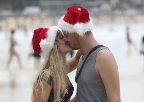 French travelers Elodie Maire, left, and Kevin Padozzi celebrate Christmas Day at Bondi Beach in Sydney. Picture: AP