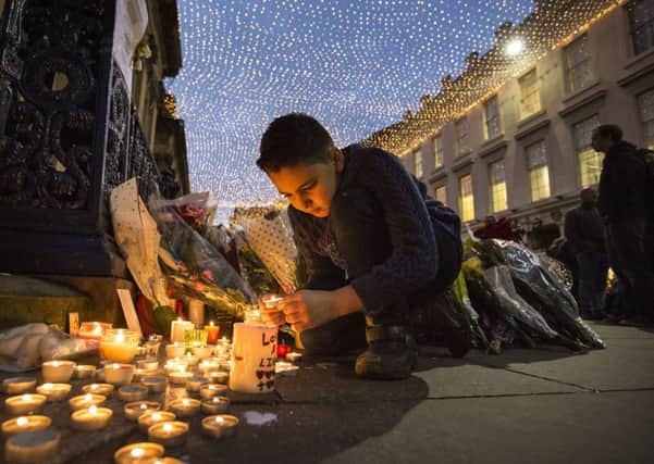 Danyil McLellan, nine, from Royston, Glasgow places a candle outside the GOMA in Royal Exchange Square, Glasgow. Picture: Robert Perry
