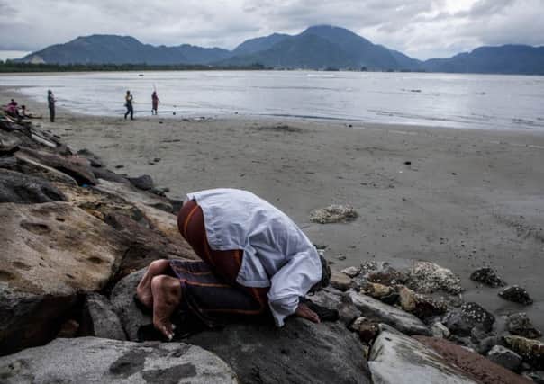 A fisherman pays his respects to the dead in Banda Aceh, Indonesia, which was hardest hit by the disaster. Picture: Getty