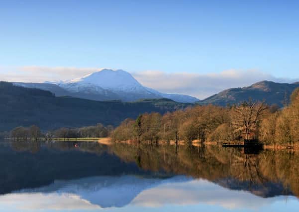Snow covered mountain tops of  Ben Lomond are reflected on the still water of Loch Ard. Picture: SWNS