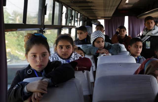 Palestinian children who had been promised a day out in Israel wait patiently on the blocked bus at Erez crossing. Picture: AFP