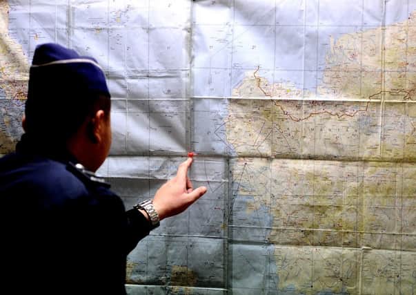 An Indonesia Search and Rescue officer inspects the operational air navigation map during the search for the missing plane. Picture: Getty