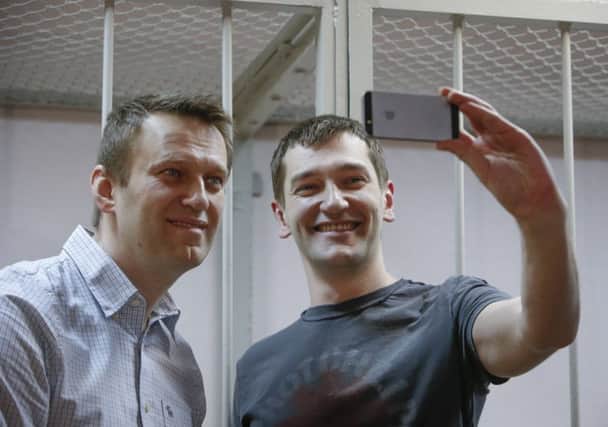 Brothers Alexei, left, and Oleg Navalny take a selfie in front of the defendants cage yesterday. Picture: Reuters