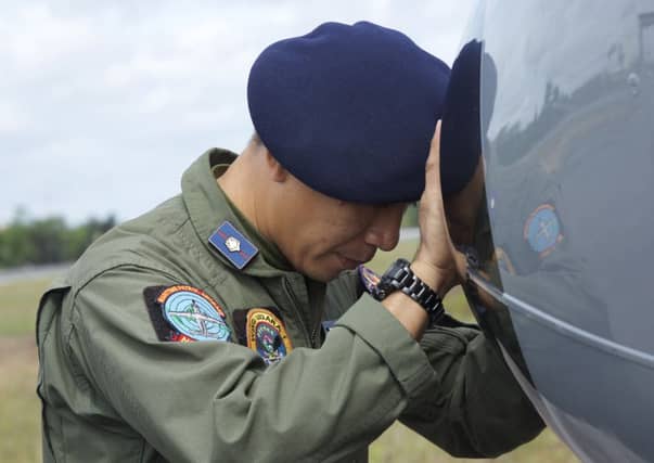 An Indonesian Navy airman prays on his plane before searching the waters near Bangka Island. Picture: Getty