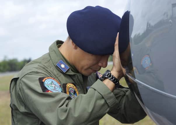 An Indonesian Navy airman prays on his plane before searching  the waters near Bangka Island. Picture: Getty