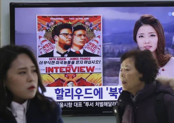 A poster of Sonys The Interview is shown during a news report being screened at Seoul Railway Station in South Korea. Picture: AP
