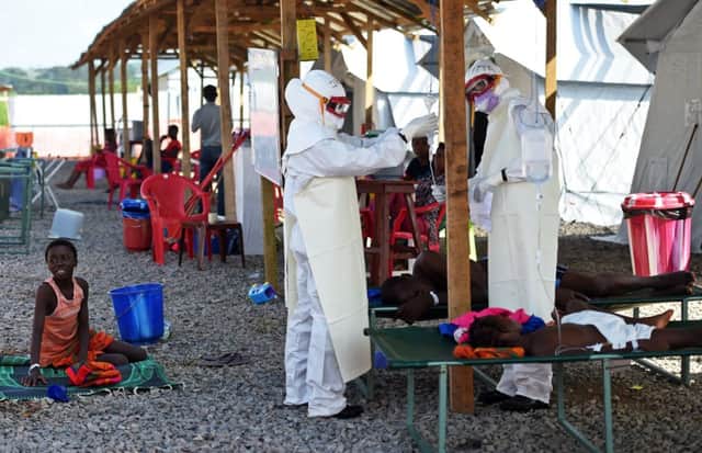 Health workers wearing personal protective equipment assist an Ebola patient in Sierra Leone. Picture: Getty