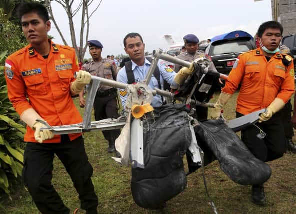 National Search and Rescue Agency personnel carry recovered seats from the wreckage of Air Asia flight 8501. Picture: AP
