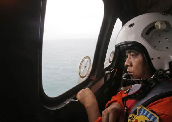 A crew member of an Indonesian Air Force NAS 332 Super Puma helicopter looks out of the window. Picture: AP