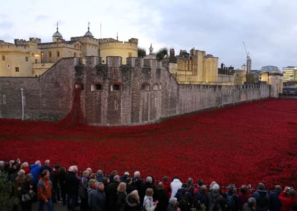 Visitors at 'Blood Swept Lands and Seas of Red' by artist Paul Cummins at the Tower of London. Picture: PA