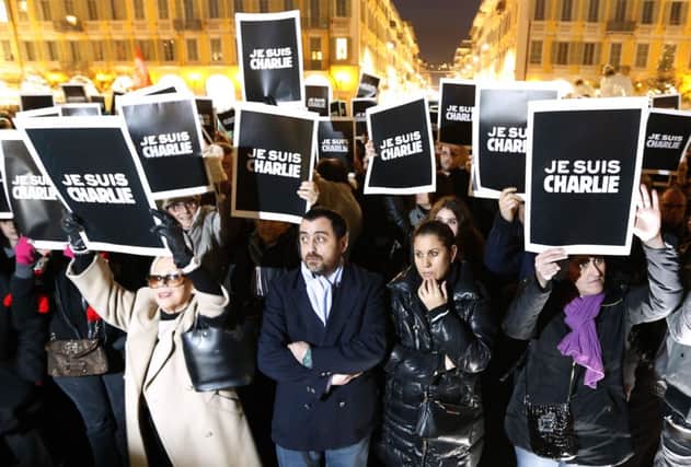 People hold up placards reading in French, "I am Charlie" during a gathering in Nice. Picture: Getty