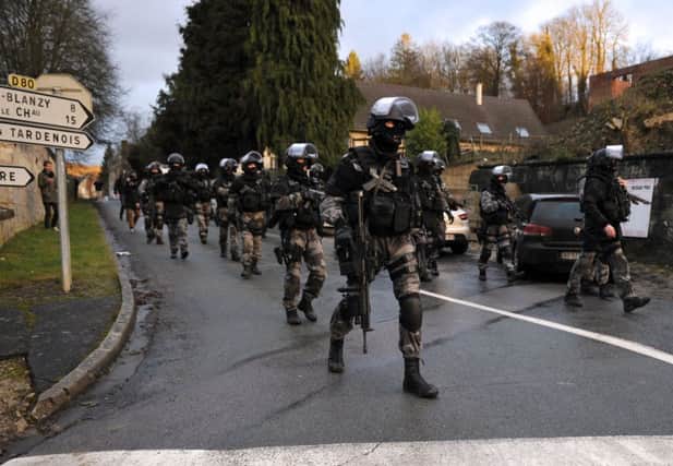 Heavily armed members of the French police special forces walk into Corcy, in northern France. Picture: Getty