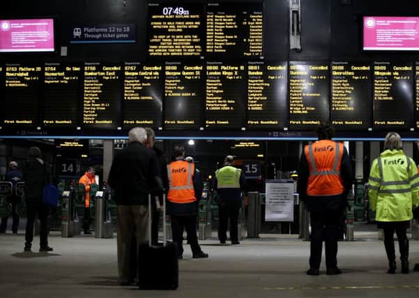 Commuters look on helpessly at Waverley Station in Edinburgh as train services are cancelled. Picture: Hemedia
