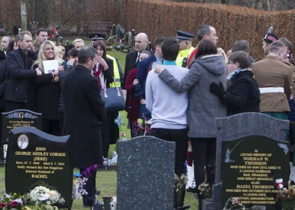 Linda McComiskie shouts abuse to Stacy(grey on right) as the coffin is placed at the grave by soldiers. Picture: Paul Reid