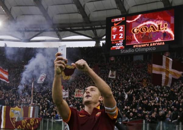 Francesco Totti celebrates his, and Roma's, second goal by taking a selfie with the fans. Picture: AP