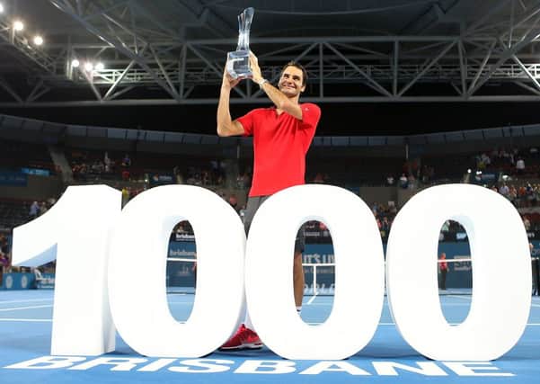 Roger Federer holds the Roy Emerson trophy after winning his 1000th match. Picture: Getty