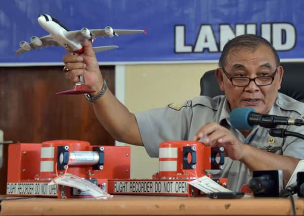 Tatang Kurniadi of the National Transportation Safety Committee (KNKT) with a flight data recorder (FDR) and a cockpit voice recorder (CVR). Picture: Getty