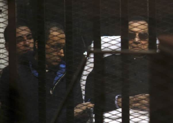 Ousted Egyptian President Hosni Mubarak, 86, lies on a gurney, next to his son Gamal, second left, in the defendants cage. Picture: AP