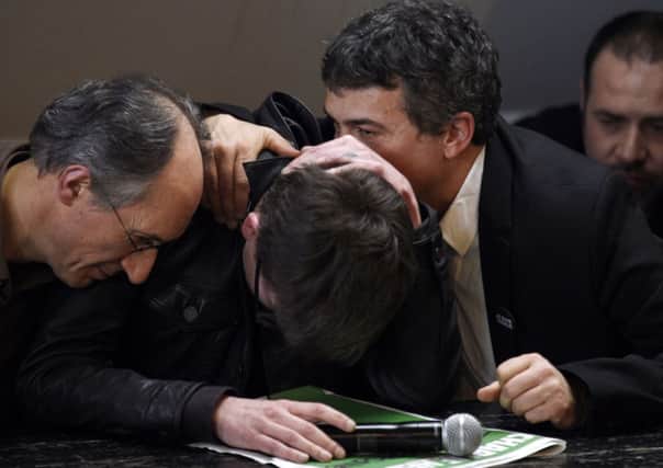 French cartoonist Renald Luzier, aka Luz (C), is comforted by editor  Gerard Briard (L) and editorialist Dr Patrick Pelloux. Picture: Getty