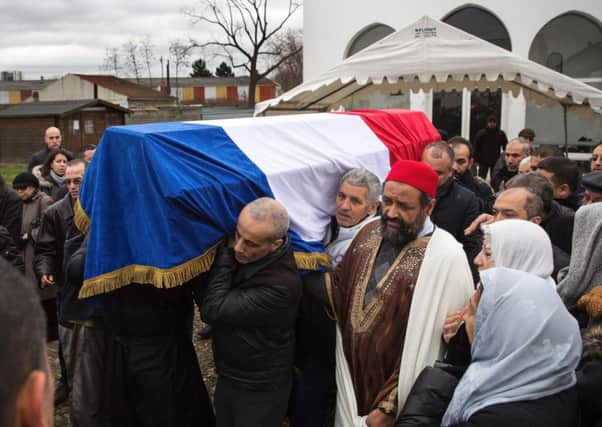A coffin containing the body of a murdered police officer is carried during a funeral at a muslim cemetary. Picture: Getty